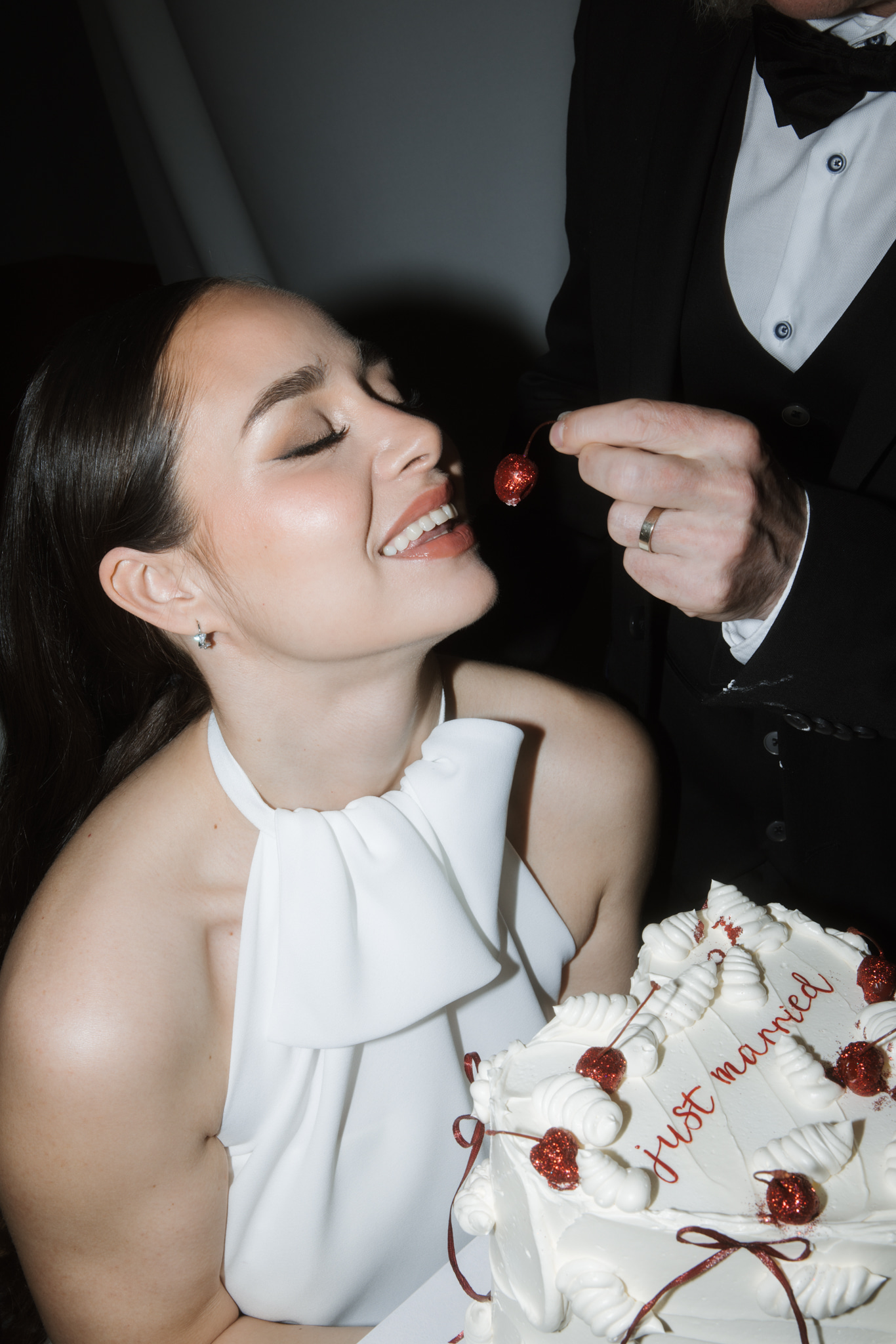 Braut nascht Kirsche von der Hochzeitstorte bei Hochzeit in Berlin